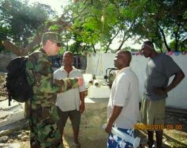 LCDR Russell assists well pump trouble shooting at a Grand Goave IDP Camp