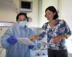 Staff volunteers demonstrate the use of scrub-the-hub protocol checklist