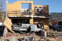 A house and a car were destroyed by a tsunami in the coastal city of Dichato, Chile, located about 15 km north of Concepcion, Chile. The tsunami height was about 10 meters (32 feet). Several hundred homes were destroyed in this city as a result of the M 8