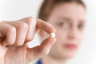 Here is an image of a girl holding a pill.