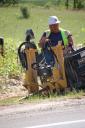 A construction worker uses machinery to dig a hole to run fiber-optic cable