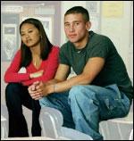 Two teens sitting on a desk at school
