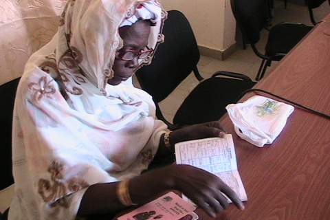 A Senegalese woman examines health insurance information.