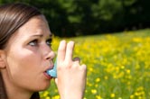 A woman uses her inhaler.