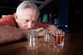 A man binge drinks at a bar.