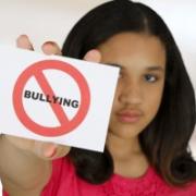 A girl holding a sign promoting not bullying.