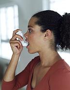 A young woman about to use an inhaler.