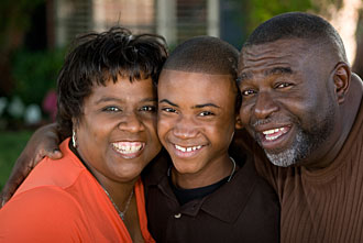Image of boy with parents smiling