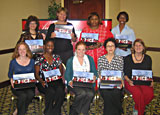 In Canton, Ohio, 9 women pose holding their speaker kits from a Champions training class.
