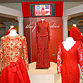 5 mannequins wearing First Ladies red dresses on display on a white dais.