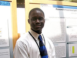 2008 intern Winnon Brunson standing in front of research poster on research misconduct policies of scientific journals