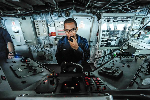 Seaman Andrew Dowe communicates using a sound-powered telephone while steering the amphibious assault ship USS Boxer (LHD 4). Boxer is deployed in the U.S. 7th Fleet area of responsibility conducting maritime security operations and theater security cooperation efforts as part of the Boxer Amphibious Ready Group.  U.S. Navy photo by Mass Communication Specialist Seaman Veronica Mammina (Released)  130928-N-GM561-263