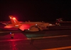 A U.S. Navy F/A-18F Super Hornet is prepared for a nighttime catapult launch 