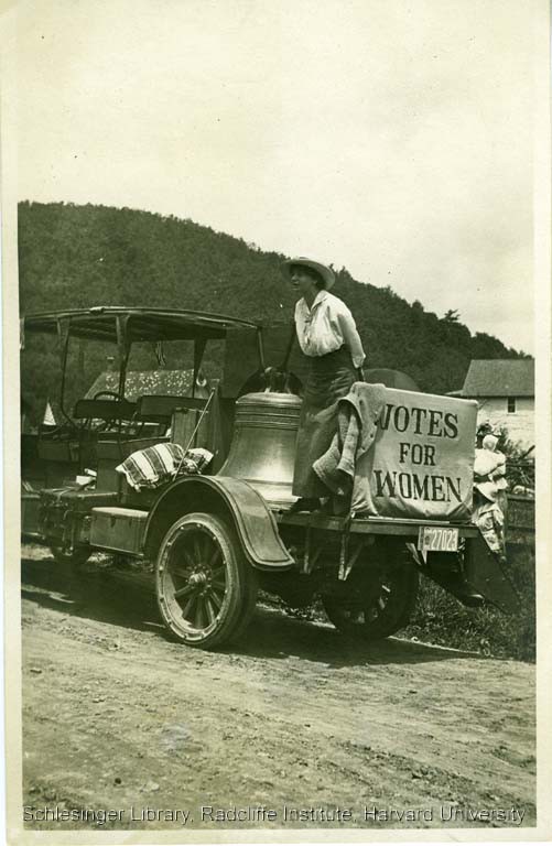  Louise Hall speaking from the back of the vehicle holding the Liberty Bell and a "Votes for Women" banner during a suffrage campaign stop in Pennsylvania, 1915.