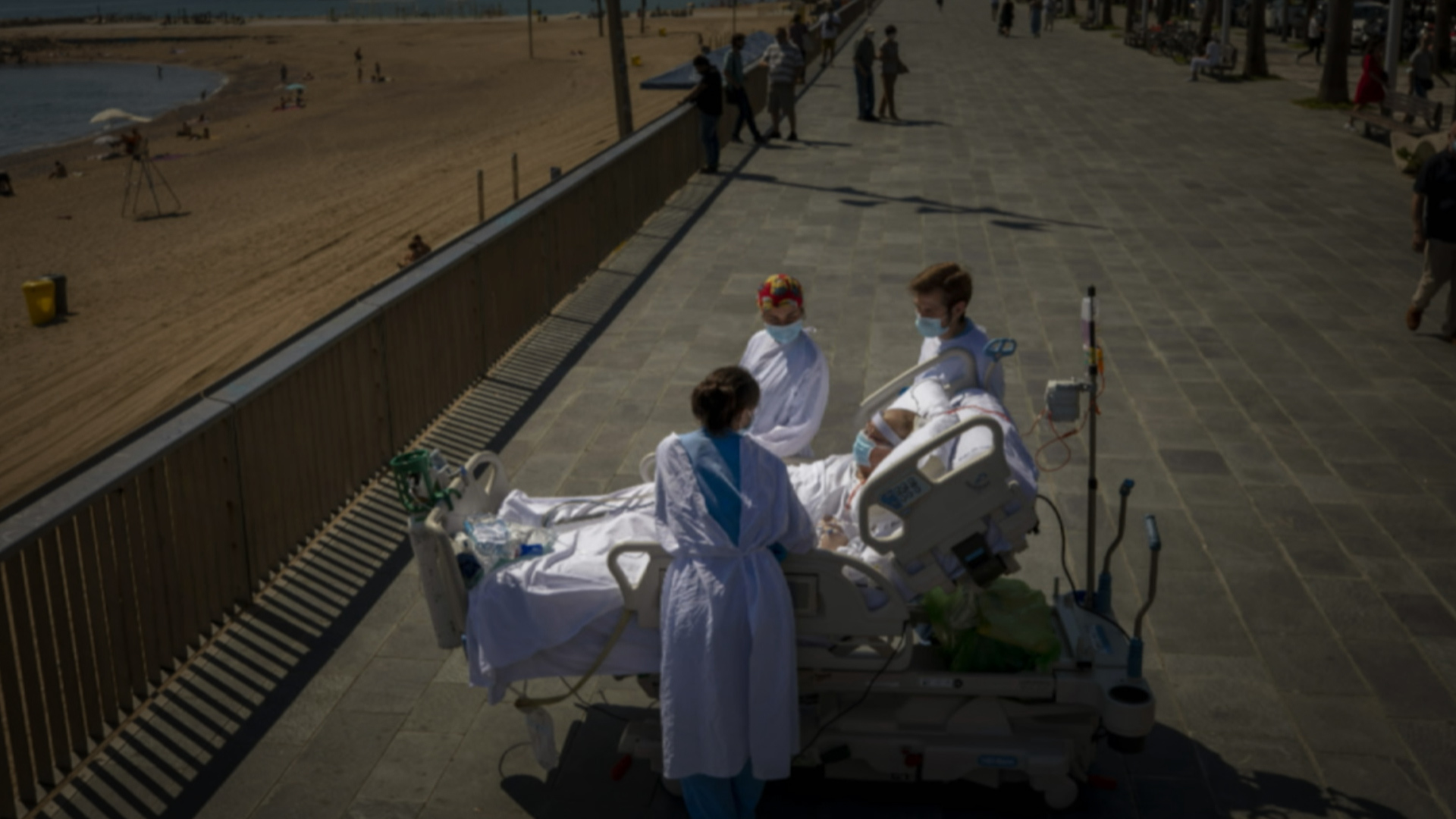 Francisco Espana, 60, is surrounded by members of his medical team as he looks at the Mediterranean sea from a promenade next to the “Hospital del Mar” in Barcelona, Spain, Friday, Sept. 4, 2020.