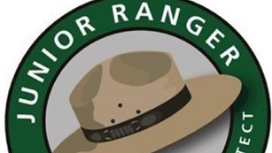 Computer graphic of NPS flat hat surrounded by text 