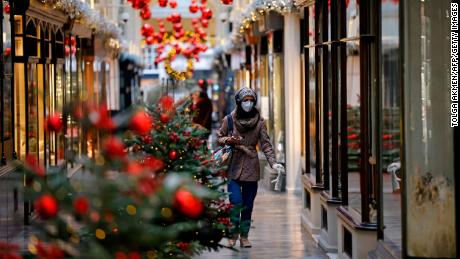 A pedestrian wearing a protective face covering to combat the spread of the coronavirus, walks past Christmas-themed window displays inside Burlington Arcade in central London on November 27, 2020, as life under a second lockdown continues in England. - England will return to a regional tiered system when the national stay-at-home order ends on December 2, and 23.3 million residents in the worst-hit areas are set to enter the &quot;very high&quot; alert level. (Photo by Tolga Akmen / AFP) (Photo by TOLGA AKMEN/AFP via Getty Images)