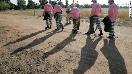 In this December 2007 file photo, members of the Maricopa County DUI chain gang are escorted to their assignment in Phoenix. National lawmakers are expected on Wednesday, December 2, 2020, to introduce a joint resolution aimed at striking language from the U.S. Constitution that enshrines a form of slavery in America&#39;s foundational documents. Many Americans will recognize modern-day prison labor as chain gangs deployed from prison facilities for agricultural and infrastructure work. 
