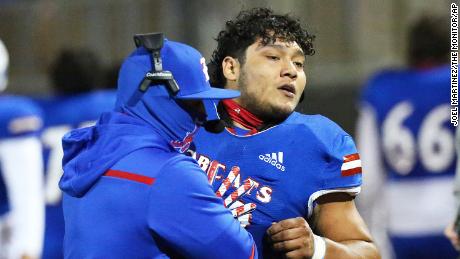 Edinburg&#39;s Emmanuel Duron is pulled from the field by coaching staff after charging a referee during a high school football zone play-in game against Pharr-San Juan-Alamo on Thursday, Dec. 3, 2020, in Edinburg, Texas. Duron came running from the sideline area after the referee announced his ejection, slamming into the official. Duron was escorted from the stadium by police. (Joel Martinez/The Monitor via AP)