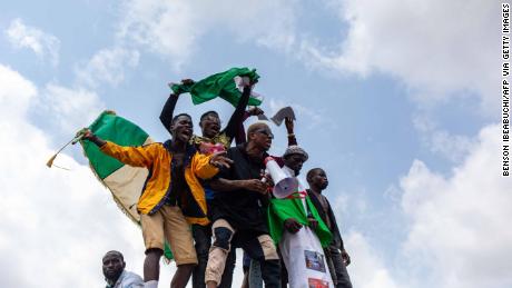 Nigerian youths seen waving the Nigerian national flag in front of a crowd in support of the ongoing protest against the unjust brutality of The Nigerian Police Force Unit named Special Anti-Robbery Squad (SARS) in Lagos on October 13, 2020