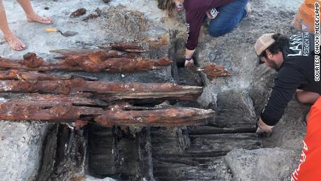 Dorothy Rowland and Nick Budsberg, both members of the Lighthouse Archaeological Program, examine the shipwreck on Crescent Beach.