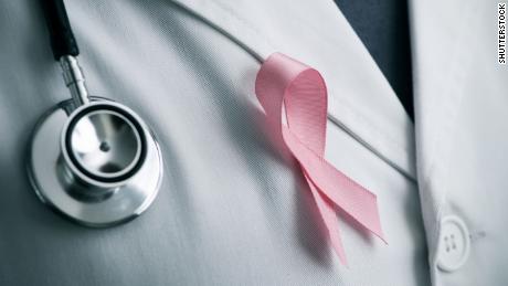 closeup of a young caucasian doctor man with a pink ribbon for the breast cancer awareness pinned in the flap of his white coat; Shutterstock ID 724387357; Job: CNN Digital