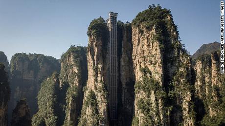TOPSHOT - This picture taken on November 13, 2020 shows shows an aerial view of the Bailong elevators in Zhangjiajie, China&#39;s Hunan province. - Towering more than 300 metres (1,000 feet) up the cliff face that inspired the landscape for the blockbuster movie &quot;Avatar&quot;, the world&#39;s highest outdoor lift whisks brave tourists to breathtaking views. (Photo by WANG ZHAO / AFP) / TO GO WITH: China technology film tourism transport, by Ludovic EHRET (Photo by WANG ZHAO/AFP via Getty Images)