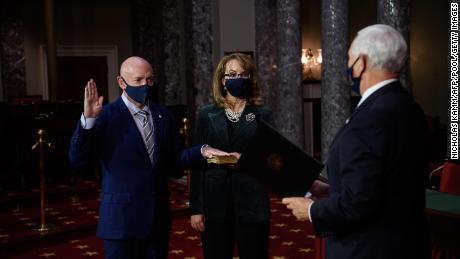 US Democratic Senator from Arizona and former NASA astronaut, Mark Kelly (L), with his wife former US Representative from Arizona Gabby Giffords, is sworn in by Vice President Mike Pence (R) during a ceremonial event at the US Capitol in Washington, DC, on December 2, 2020. 
