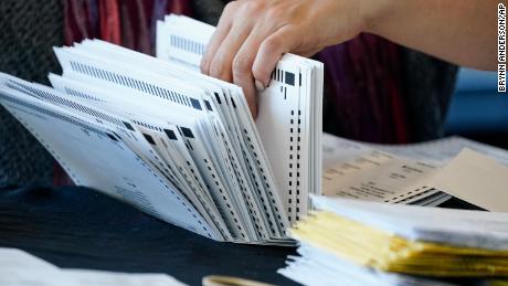 An election worker handles ballots as vote counting in the general election continues at State Farm Arena on Thursday, Nov. 5, 2020, in Atlanta. 