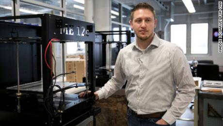 Zac DiVencenzo, COO of Juggerbot 3D, stands next to a 3D printer in Youngstown, OH on March 6, 2019.