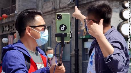 BEIJING, CHINA - APRIL 25: People wearing face masks make livestreaming on Qianmen Street on April 25, 2020 in Beijing, China. (Photo by Zhang Yu/China News Service via Getty Images)