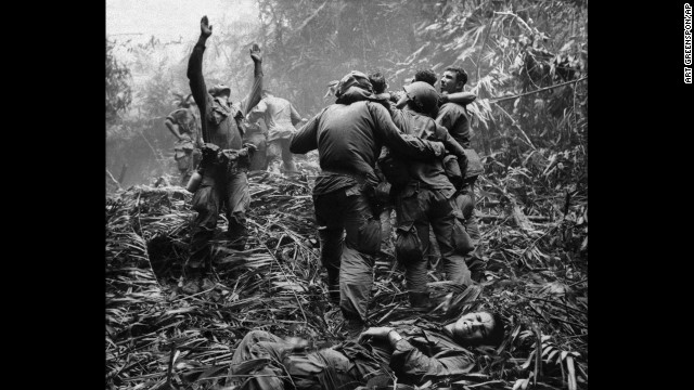 As fellow troopers aid wounded comrades, the first sergeant of A Company, 101st Airborne Division, guides a medevac helicopter through the jungle foliage to pick up casualties suffered during a five-day patrol near Hue, April 1968. (AP Photo/Art Greenspon)