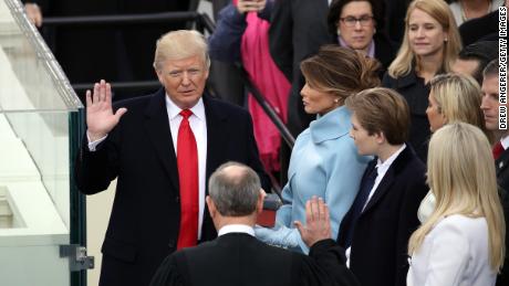 WASHINGTON, DC - JANUARY 20:  Supreme Court Justice John Roberts (2L) administers the oath of office to U.S. President Donald Trump (L) as his wife Melania Trump holds the Bible on the West Front of the U.S. Capitol on January 20, 2017 in Washington, DC. In today&#39;s inauguration ceremony Donald J. Trump becomes the 45th president of the United States.  (Photo by Drew Angerer/Getty Images)
