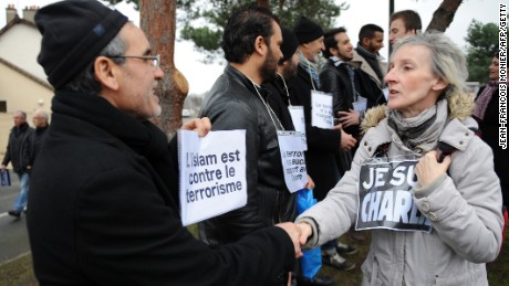 Caption:A woman holding a sign reading &#39; Je suis Charlie&#39; shakes hands to a Muslim with a sign reading&#39;Islam is against terrorism&#39; in the Sablons neighborhood of Le Mans, western France, on January 10, 2015, in front of the mosque against which bullets were fired and 3 grenades launched on January 8. Tens of thousands of people staged rallies across France following three days of terror and twin siege dramas that claimed 17 victims, including the victims of the first attack by armed gunmen on the offices of French satirical newspaper Charlie Hebdo in Paris on January 7. AFP PHOTO / JEAN-FRANCOIS MONIER (Photo credit should read JEAN-FRANCOIS MONIER/AFP/Getty Images)