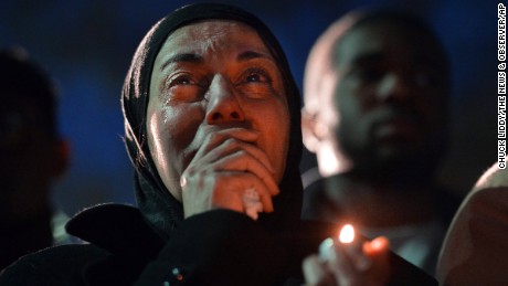 A woman cries during a vigil as she watches photos projected on a screen of three people who were killed at a condominium near UNC-Chapel Hill, Wednesday, Feb. 11, 2015, in Chapel Hill, N.C. Craig Stephen Hicks appeared in court Wednesday on charges of first-degree murder in the deaths Tuesday of Deah Shaddy Barakat, his wife Yusor Mohammad and her sister Razan Mohammad Abu-Salha.