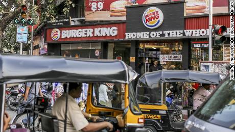 Auto-rickshaws sit in traffic outside a Burger King restaurant, operated by Burger King Worldwide Inc. and the Everstone Group, in Mumbai, India, on Monday, March 26, 2018. A pickup in the economy and growing demand from the planet&#39;s largest youth population are boosting fast-food sales in India. Photographer: Dhiraj Singh/Bloomberg via Getty Images