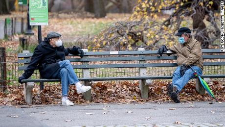 NEW YORK, NEW YORK - DECEMBER 02: Two men have a conversation while socially distancing and wearing masks in Central Park during the coronavirus (COVID-19) pandemic on December 02, 2020 in New York City. The pandemic has caused long-term repercussions throughout the tourism and entertainment industries, including temporary and permanent closures of historic and iconic venues, costing the city and businesses billions in revenue. (Photo by Roy Rochlin/Getty Images)