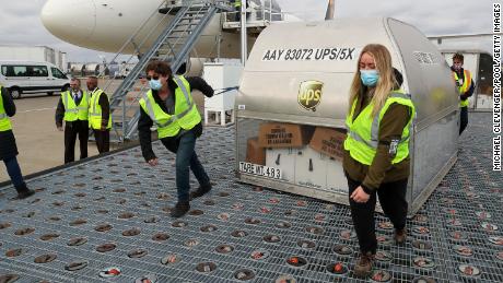 LOUISVILLE, KY - DECEMBER 13: UPS employees move one of two shipping containers  containing the first shipments of the Pfizer and BioNTech COVID-19 vaccine  a ramp at UPS Worldport in Louisville, Kentucky, on   December 13, 2020.   The flight originated in Lansing, Michigan. (Photo by Michael Clevenger - Pool/Getty Images)