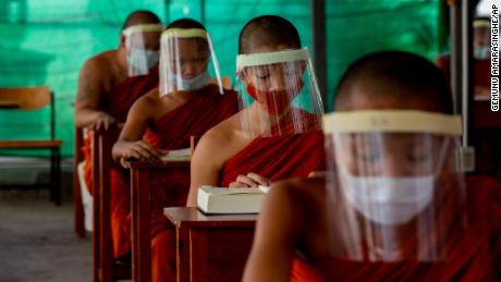 Novice Buddhist monks with protective masks and face shields, seated maintaining social distancing participate in a religious class at Molilokayaram Educational Institute in Bangkok, Thailand, Wednesday, April 15, 2020. All schools in Thailand were closed earlier than the scheduled school break due to the COVID-19 outbreak but about 200 novice monks remain in the monastic school due to travel restrictions and lockdowns implemented in provinces in Thailand. (AP Photo/Gemunu Amarasinghe)