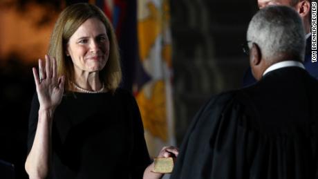 Judge Amy Coney Barrett holds her hand on the Holy Bible as she is sworn in as an associate justice of the U.S. Supreme Court by Supreme Court Justice Clarence Thomas on the South Lawn of the White House in Washington, U.S., October 26, 2020.   REUTERS/Tom Brenner