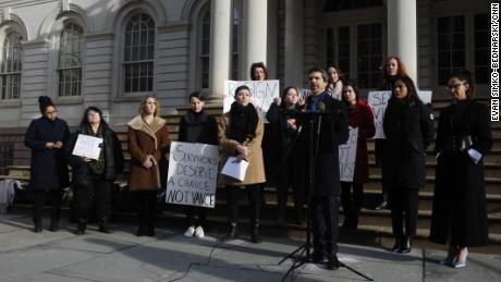 Marissa Hoechstetter (center) and her attorney Anthony DiPietro (podium) gathered with supporters Thursday on the steps of City Hall in New York to call for the resignation of Manhattan District Attorney Cyrus Vance, who they say was too lenient with Robert Hadden, the former Columbia University OB-GYN who stands accused of sexually abusing dozens of women.