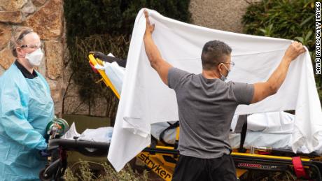 Healthcare workers transport a patient on a stretcher into an ambulance at Life Care Center of Kirkland on February 29, 2020 in Kirkland, Washington. Dozens of staff and residents at Life Care Center of Kirkland are reportedly exhibiting coronavirus-like symptoms, with two confirmed cases of (COVID-19) associated with the nursing facility reported so far. (David Ryder/Getty Images)