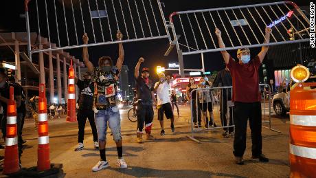 Protesters hold up metal gates as they build a barrier in a roadway on Saturday, May 30, in Las Vegas.