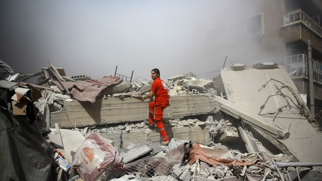 A member of the Syrian Red Crescent inspect rubble searching for victims in the rebel-held area of Douma, east of the capital Damascus, following shelling and air raids by Syrian government forces on August 22, 2015. At  least 20 civilians and wounded or trapped 200 in Douma, a monitoring group said, just six days after regime air strikes killed more than 100 people and sparked international condemnation of one of the bloodiest government attacks in Syria&#39;s war.   AFP PHOTO / ABD DOUMANY        (Photo credit should read ABD DOUMANY/AFP/Getty Images)