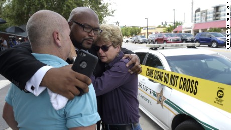 Terry DeCarlo, executive director of the LGBT Center of Central Florida, left, Kelvin Cobaris, pastor of The Impact Church, center, and Orlando City Commissioner Patty Sheehan console each other after the shooting at the Pulse nightclub in Orlando, Florida, Sunday, June 12.