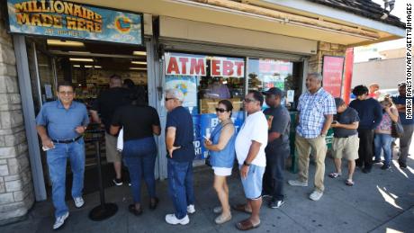 Customers buy Mega Millions tickets hours before the draw of the  USD 1 billion jackpot, at the Bluebird Liquor store in Torrance, California on October 19, 2018. 
