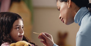 mother taking daughter's temperature.