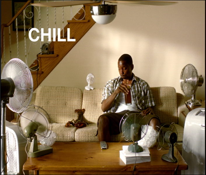 Photo of a man sitting next to a lobster with several fans