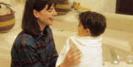 Mother drying child from a bath